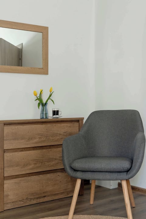 A small nook with a dresser and comfy chair offers a perfect spot for a moment of rest or morning routine.