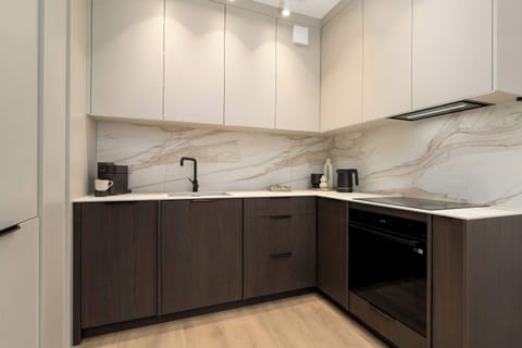 A functional and modern kitchen in neutral tones, equipped with a built-in oven and a long worktop. Perfect for preparing home-cooked meals.