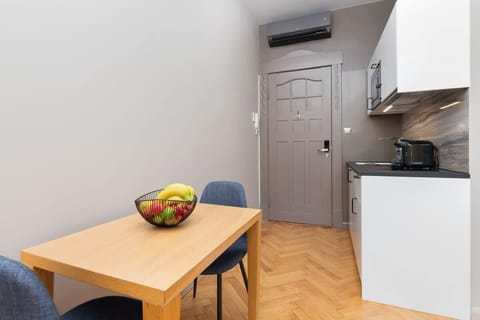 The kitchenette's compact design includes a fridge, microwave, and dining table for your convenience.