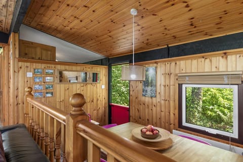Small bannister overlooking the dining area, window and timber walls