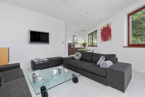 Relax in this inviting sitting space with a sleek TV setup and glass coffee table.

