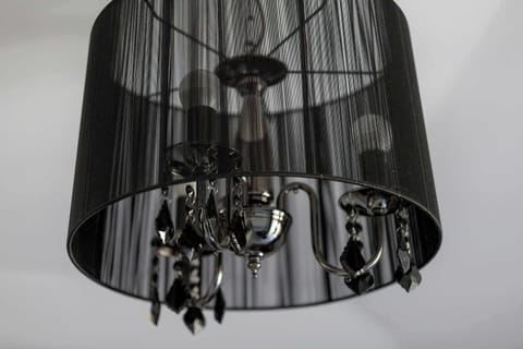 Stylish black chandelier hanging in the center of the room.