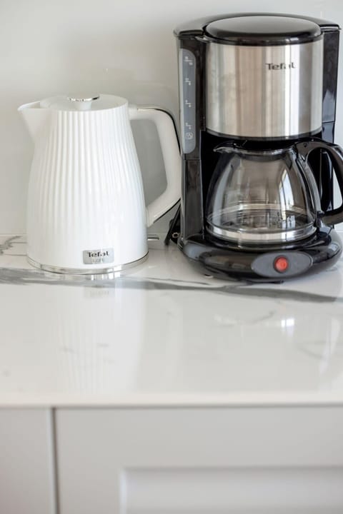 A close-up of a modern kettle on a kitchenette counter. Great for tea or coffee lovers.