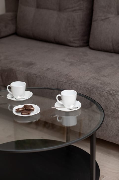 A minimalist coffee table in a living room with two white cups and saucers. Ideal for a relaxing coffee break.
