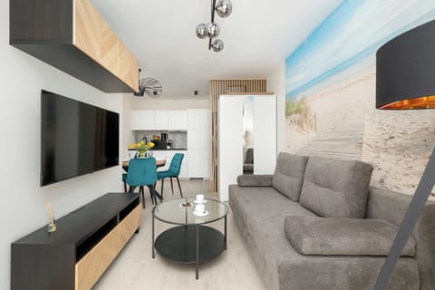 A bright living room with a gray sofa and a flat-screen TV, perfect for relaxing after a busy day.