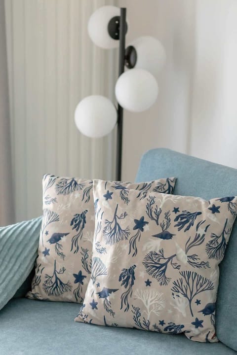 Relaxation corner with decorative sofa and cushions in a soft blue hue.