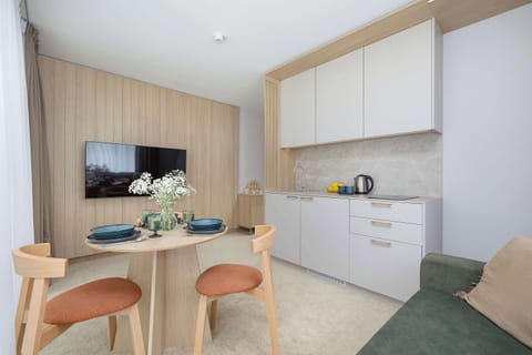 Living room with sofa bed, Smart TV, dining area and kitchenette.