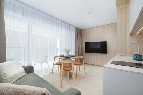 Cozy living room with sofa bed, Smart TV, dining area and access to the balcony.