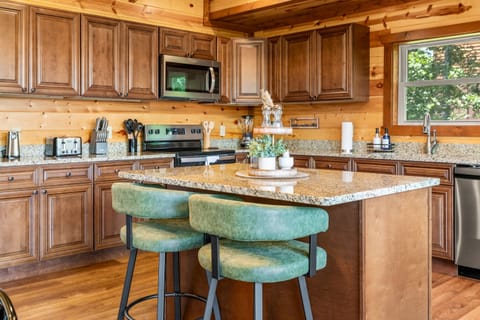 Fully equipped chef’s kitchen with granite countertops and bar seating.