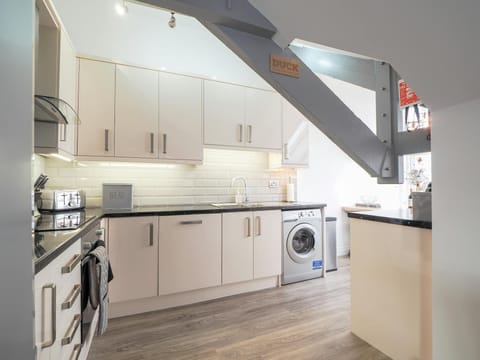 Kitchen cabinets, washing machine, toaster, sink and beam