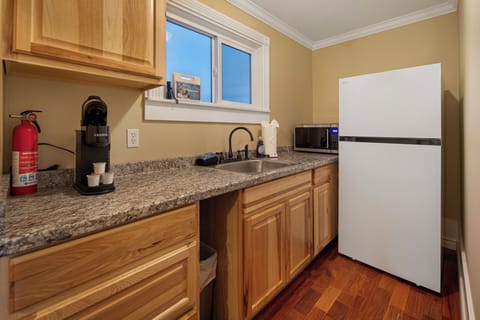 Kitchenette with Keurig coffee maker and refrigerator.