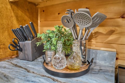 Rustic Kitchen Counter | Utensil Holder, Knife Block & Olive Oil Bottles on Marble Surface