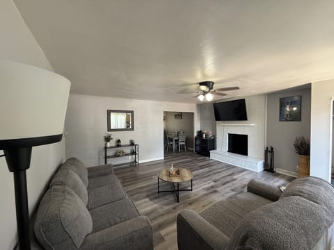 Living room has a 55” smart tv with a full size couch and loveseat