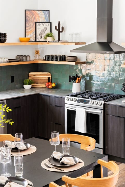 Modern kitchen with sleek design, open shelving, and a stylish dining area, perfect for gatherings.