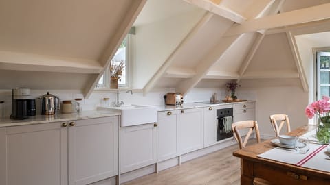 Set along one side of the open plan area, the kitchen has an oven and hob, dishwasher, fridge, Nespresso coffee machine, kettle and toaster.