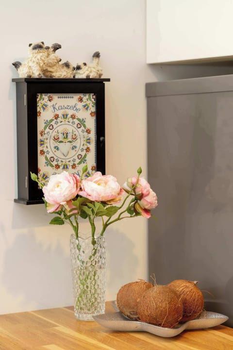 A hallway shelf decorated with a vase of flowers and small artistic accessories near the apartment entrance.