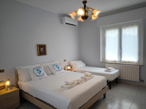 Spacious triple bedroom with double bed and single bed, ideal for families or small groups. The room is bright and air-conditioned, furnished with simplicity and comfort to ensure a relaxing stay in the villa in Peschiera del Garda.
