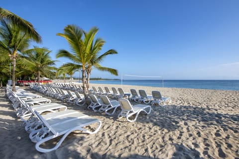 On the beach, white sand, sun loungers, beach umbrellas