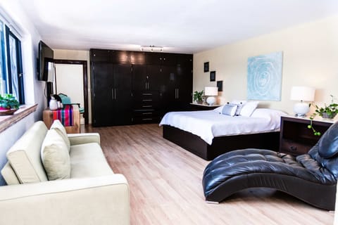 Bedroom 1 | Elegant suite with king bed and additional sofa bed, overlooking the pool