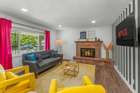 A cozy living room with large smart TV- the fireplace is not operational