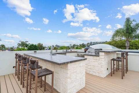 Escape to your private rooftop oasis! This stunning deck offers breathtaking views and a fully equipped outdoor kitchen, perfect for alfresco dining and entertaining. Enjoy a cocktail at the bar while soaking in the beautiful tropical scenery. 
