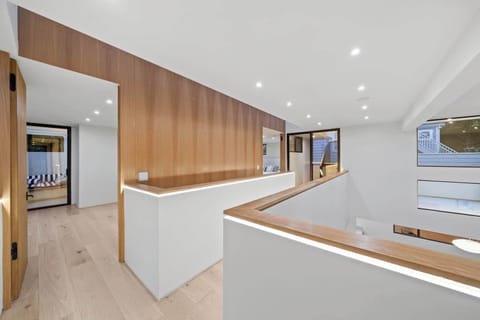 
Elegant design and natural light define this modern home. The upper hallway features beautiful wood paneling and sleek lighting, offering a stylish transition between rooms.