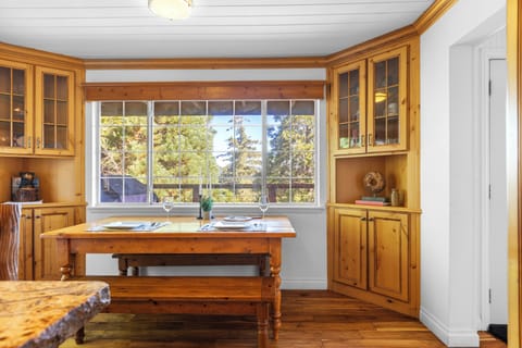 Dining nook with wooden bench and window views.