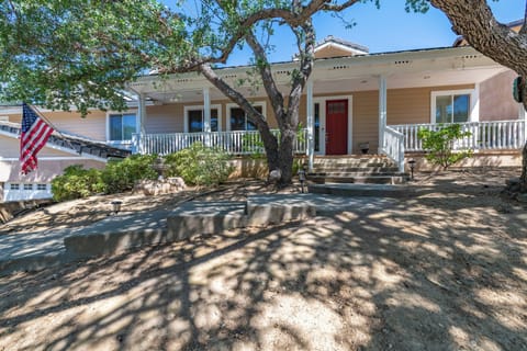 Charming single-story home with welcoming front porch, mature shade trees, and classic architectural details in a peaceful neighborhood setting.