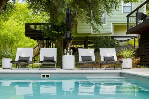 Relax by the pool with comfortable loungers and shade.