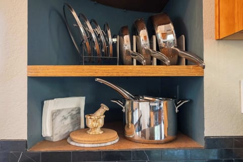 Open shelving stocked with quality cookware and serving essentials for preparing home-cooked meals.