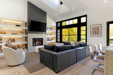 Bright and airy living room with modern design, featuring a large picture window showcasing Aspens, vaulted ceiling, and open layout.