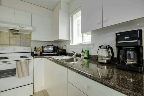 Enjoy modern appliances and sparkling countertops, with essentials like a kettle, toaster, and cookware ready for use.