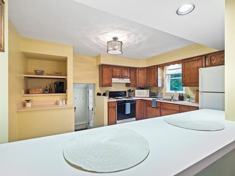 Bright kitchen with full appliances & breakfast bar seating—perfect for cooking & casual meals 🍳☕✨