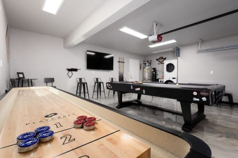 Garage game room with arcade games, shuffleboard and pool table and smart TV