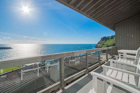 Private balcony with seating and panoramic ocean views stretching along the rugged Oregon coastline.