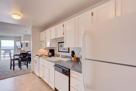 The modern kitchen boasts ample storage and counter space, perfect for preparing meals while enjoying the stunning ocean views from this Panoramic Ocean View King Bed Studio.