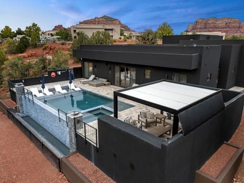 Gorgeous view of the backyard highlighting the infinity pool and outdoor seating. The perfect to relax and unwind.