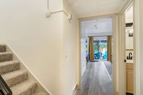 Welcoming entryway leading from the stairs to the main living areas with a direct line of sight to the backyard patio.
