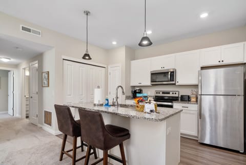 Arhaus bar stools at the kitchen island with spacious granite countertops