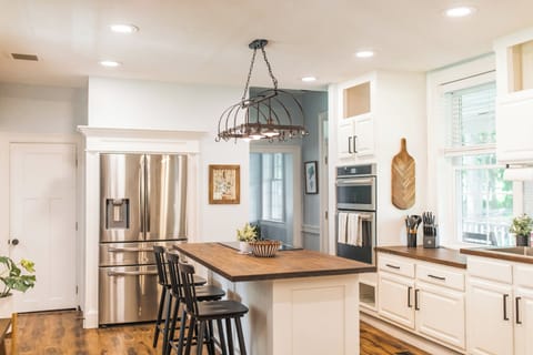 Open kitchen connected to dining room, with bar seating for three