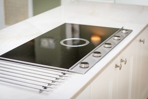 Sleek induction cooktop with integrated extractor on quartz island at 42 Lade Braes, St Andrews.