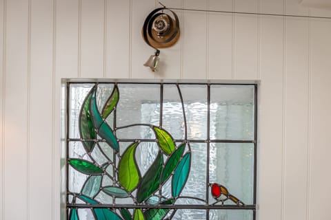 Decorative stained-glass panel with leaf and bird motif adding character to 42 Lade Braes, St Andrews.