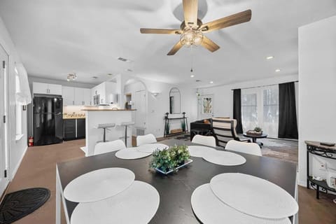 Above the table, a light fixture with a rustic yet elegant feel hangs low, casting a soft, amber glow that adds warmth to the room.