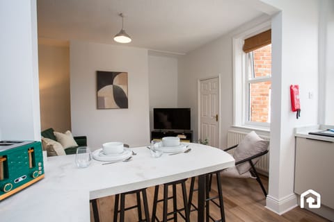Peaceful sleeping space with a neatly prepared bed, open wardrobe, and modern vanity