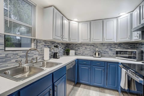 Bright kitchen with sleek cabinetry, double sink, and stainless steel appliances, fully stocked for easy at-home cooking.