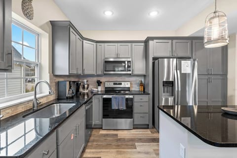 The sleek, open kitchen offers ample space & every home comfort