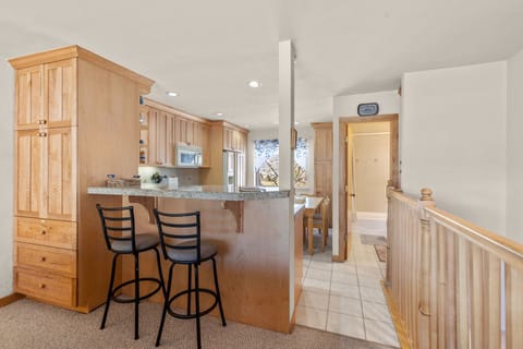 Breakfast bar between kitchen and living area with seating for 2.