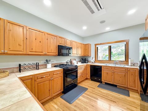 Picture morning coffee prep at this spacious counter while gazing at mountain views through the window. Every appliance at your fingertips - gas stovetop, oven, microwave, dishwasher - making gourmet meals effortless