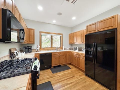 From this angle, see how completely equipped your mountain kitchen is, full-size refrigerator, gas stovetop, toaster, and every appliance you need