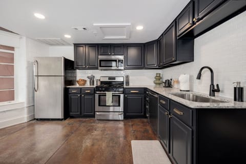Contemporary kitchen with stainless steel appliances and black cabinetry.
